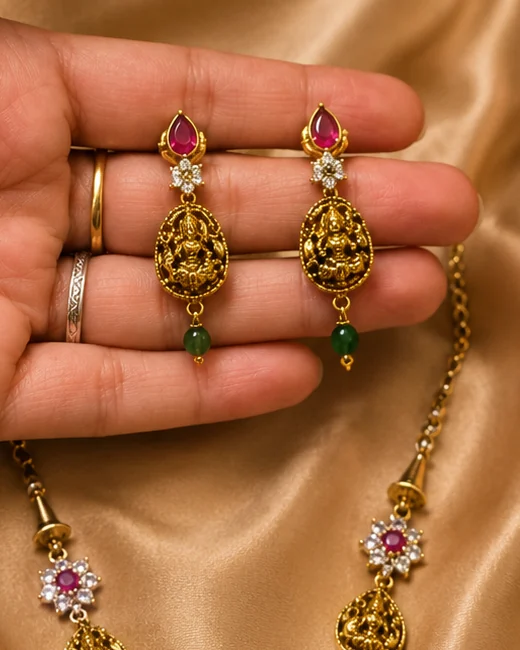 Long traditional earrings with red teardrop stones and Lakshmi medallions